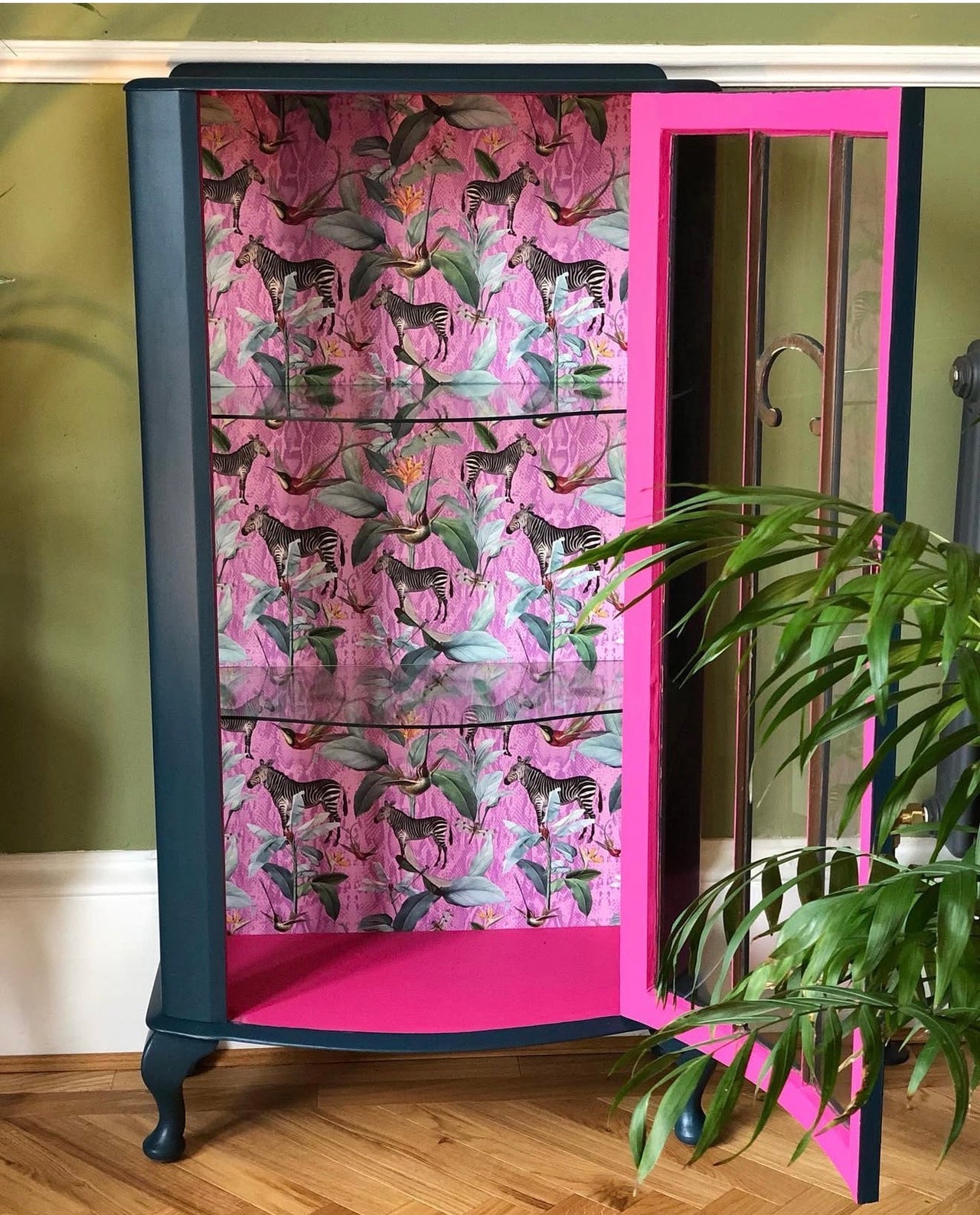 Pink and black cabinet with floral pattern on a wooden floor